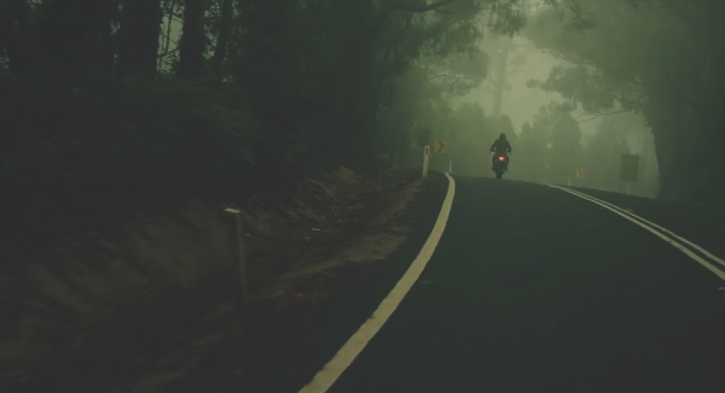 Motorcycle on a misty forest road