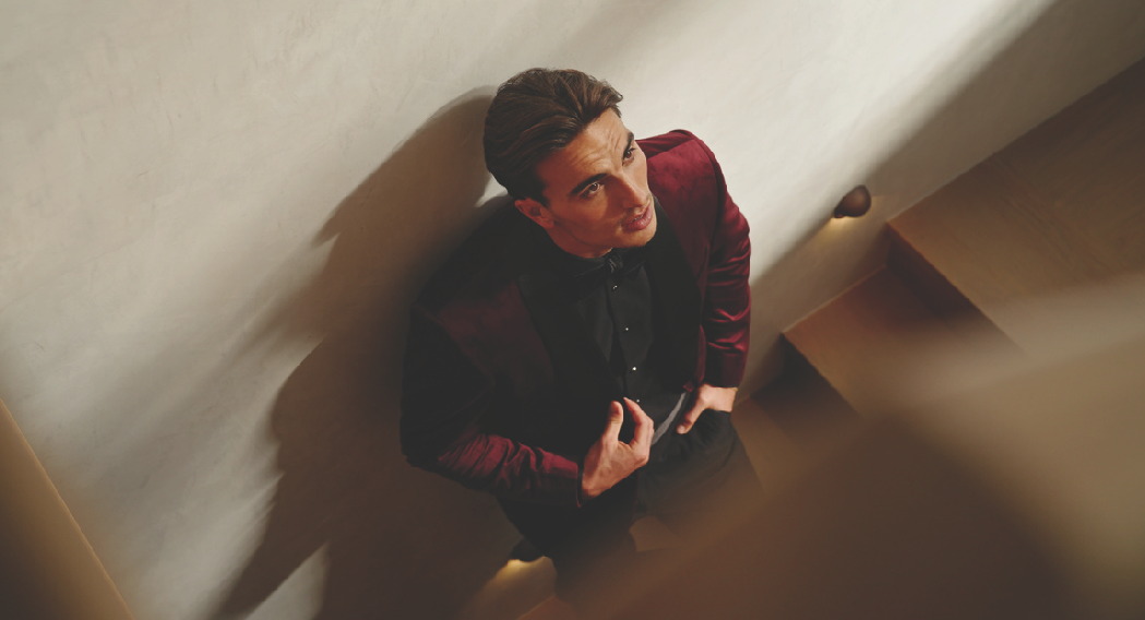Burgundy suit in a stairwell, looking up
