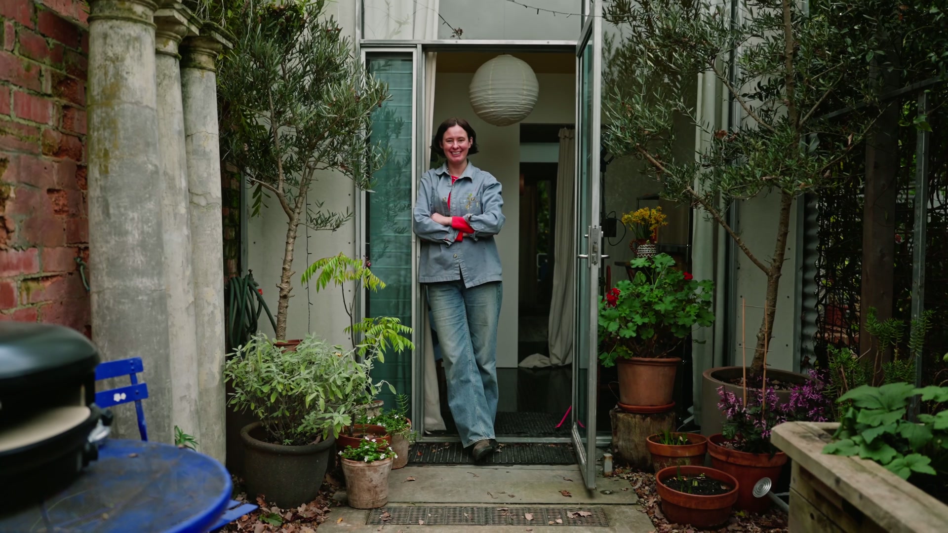 Artist in a courtyard doorway, lifestyle wide
